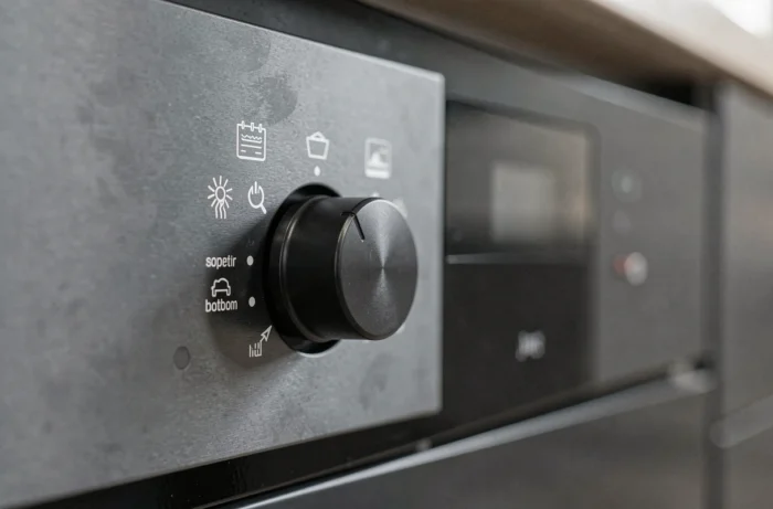 Gros plan sur les symboles et boutons de commande d'un four moderne avec icônes de modes de cuisson